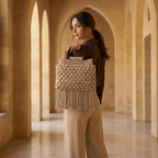 Woman holding a woven bag in a sunlit architectural interior
